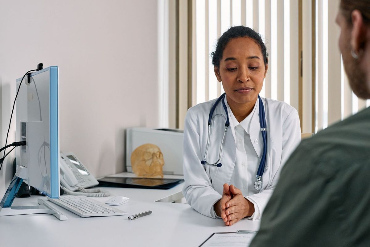 Médecin en conversation avec un patient dans un cabinet médical Médecin en conversation avec un patient dans un cabinet médical