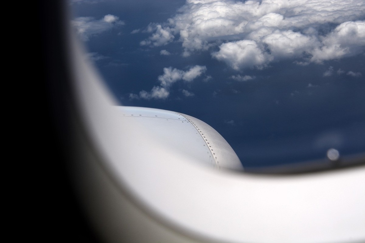 Vue extérieure d'avion montrant ciel bleu et nuages blancs