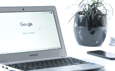 Laptop Samsung avec Google sur l'écran, smartphone et plante en pot noir à proximité