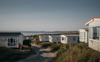 rangée de petites maisons mobiles sur dunes côtières, ciel clair
