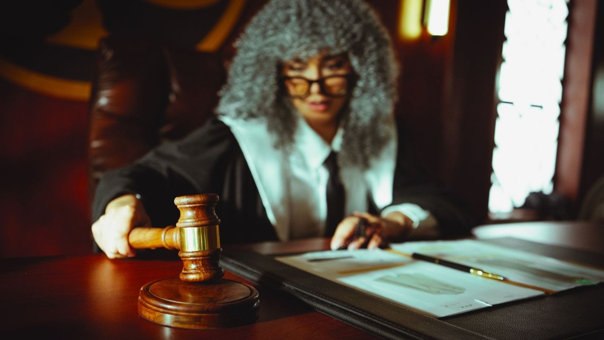 Juge en cour de justice, marteau à la main, documents sur le bureau