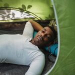 Homme repose dans une tente de camping avec moustache