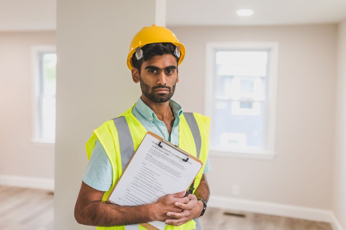 Inspecteur de chantier avec un classeur dans une pièce en construction Inspecteur de chantier avec un classeur dans une pièce en construction